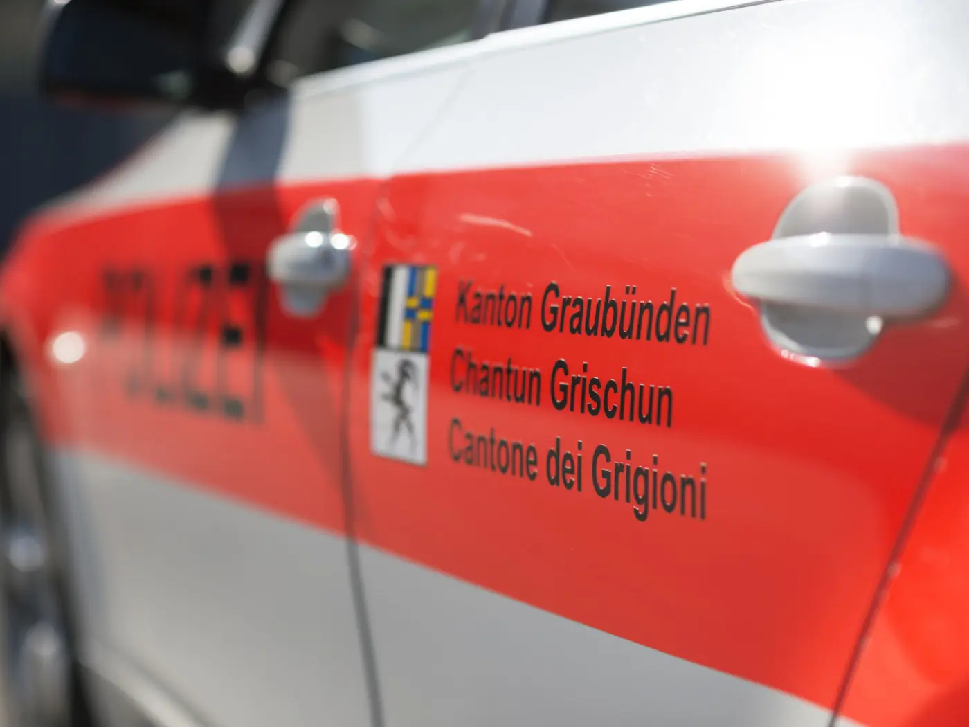 Auto della polizia con la scritta "Kanton Graubünden", "Chantun Grischun" e "Cantone dei Grigioni" sul lato.