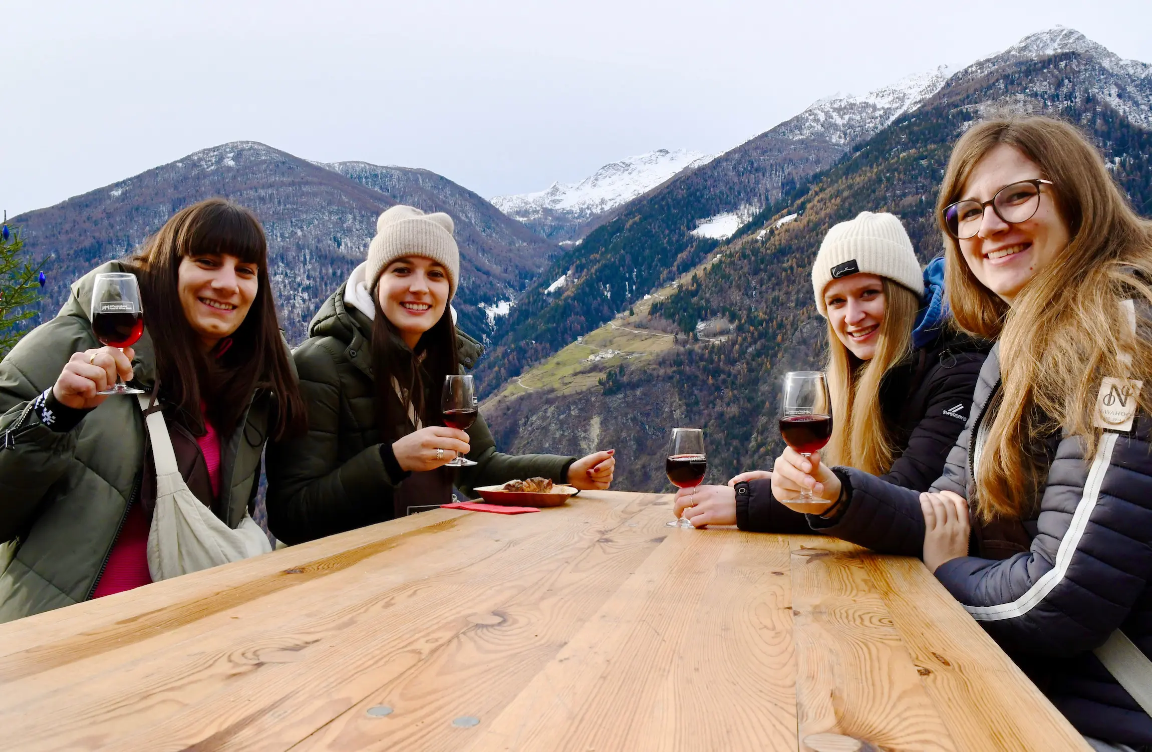 Quattro giovani donne brindano Al Cuntraband. Sullo sfondo il nucleo di Cavaione