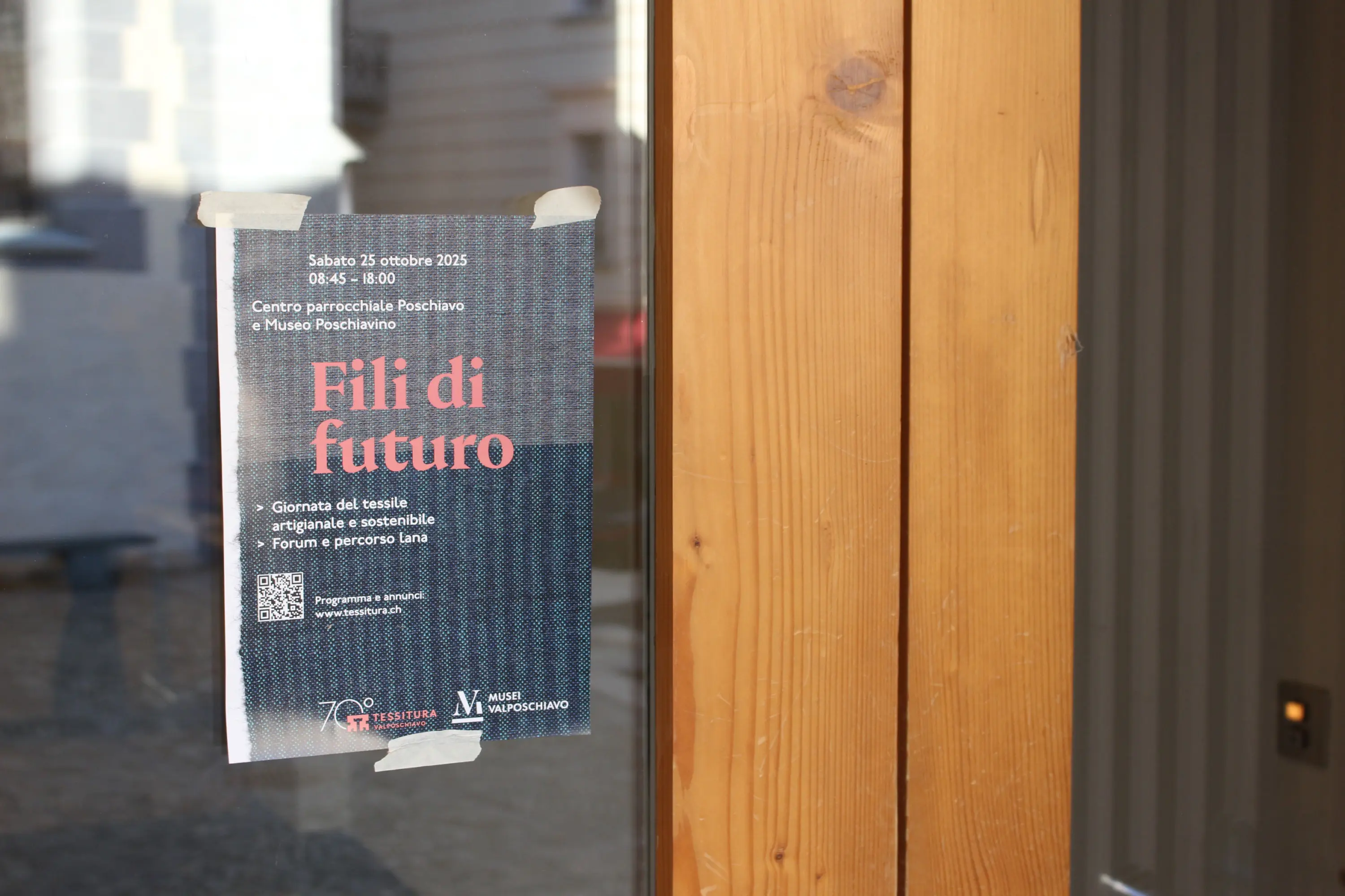 Volantino attaccato a una porta di legno che annuncia un evento intitolato "Fili di futuro". L'evento si svolgerà il 25 ottobre 2023 presso il Centro parrocchiale Pochiano e il Museo Pochiano, dalle 15: