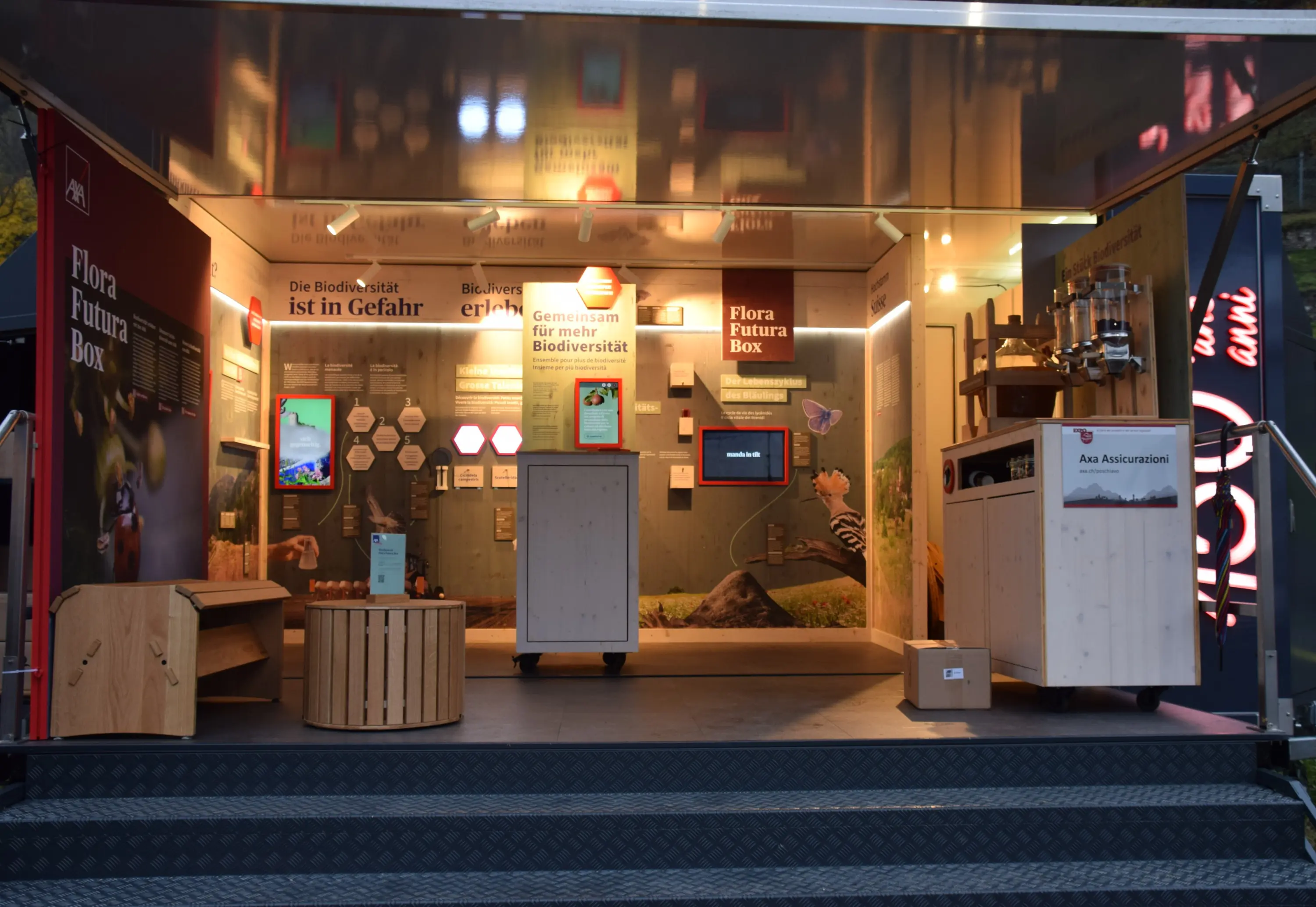 Una mostra interattiva su biodiversità, con pannelli informativi e dispositivi touchscreen. Ci sono anche espositori in legno e un'area decorata con immagini della flora e della fauna.