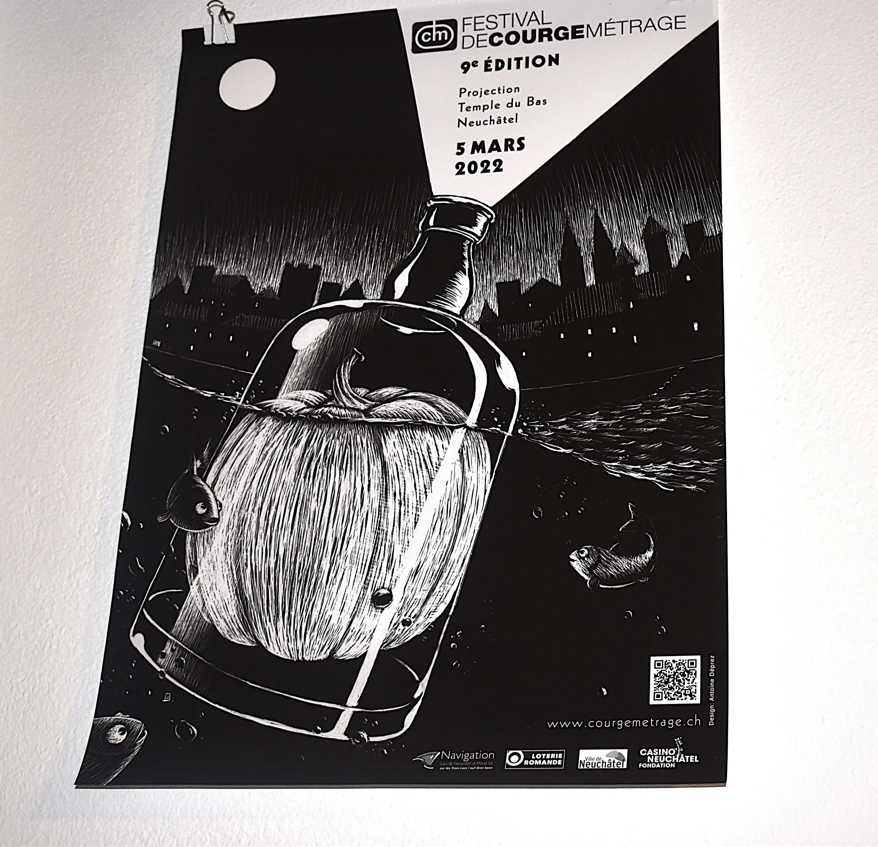 Manifesto del Festival de Cour   gementrage, 9ª edizione, con una bottiglia contenente una grande zucca e ratti nani sullo sfondo di una città. Data: 5 marzo 2022.